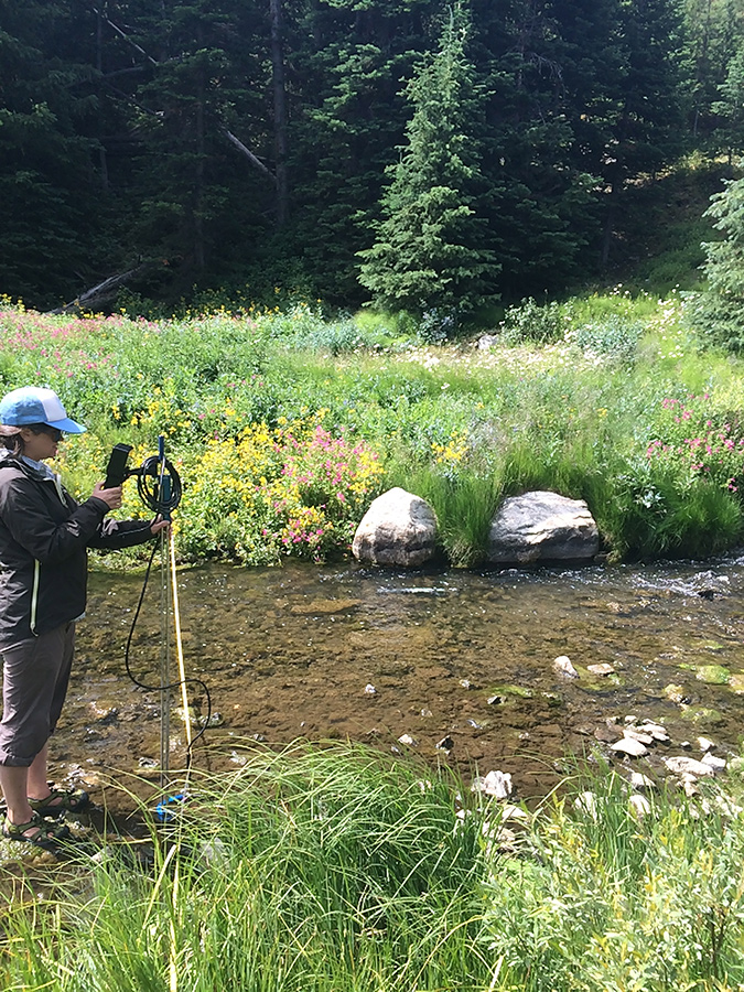 MSU researcher hard at work measuring discharge - the volume (in cfs) of water moving through a stream at a particular time.